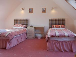 a attic room with two beds and a desk at Dolphin View - Uk30689 in Portknockie