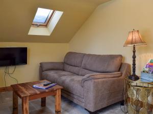 a living room with a couch and a table at Fennel Folly - Uk32608 in Manton
