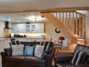 a living room with a couch and a kitchen at The Old Forge in Burshill