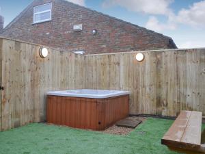 a privacy fence with a hot tub in a backyard at The Old Forge in Burshill