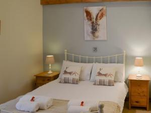 1 dormitorio con 1 cama grande y 2 mesitas de noche en Sunflower Holiday Cottage, en Alford