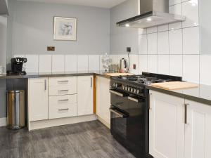 een keuken met een zwarte kachel en witte kasten bij Loweys Harbour Cottage in Bridlington