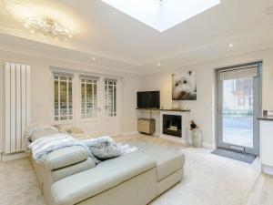 a living room with a white couch and a tv at Friars Corner in Richmond