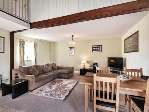 uma sala de estar com um sofá e uma mesa em The Granary - Uk36124 em Horsington