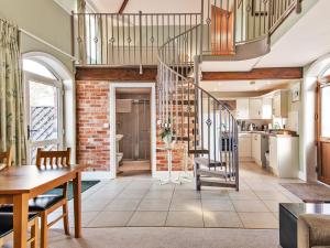 uma cozinha e sala de estar com uma escada em espiral em The Granary - Uk36124 em Horsington