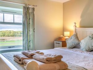 1 dormitorio con toallas en una cama con ventana en The Granary - Uk36124 en Horsington