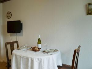 una mesa blanca con una botella de vino y copas en Tigh Beag, en Troon
