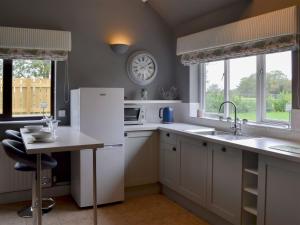 a kitchen with a white refrigerator and a table at Oxley Cottage in Orby