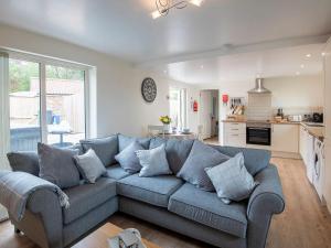 uma sala de estar com um sofá azul e uma cozinha em The Shambles em Fulletby
