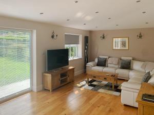 a living room with a couch and a flat screen tv at Catcleugh Bridge View in Kielder