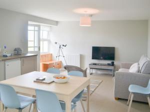 a kitchen and living room with a table and chairs at Mansefield Cottage in Boyndie