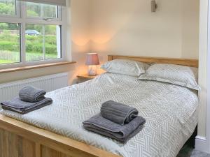 a bedroom with a bed with towels on it at Catcleugh Bridge View in Kielder