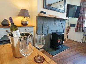 a room with two wine glasses and a fireplace at Little Nook in St Bees