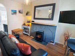 a living room with a couch and a fireplace at Little Nook in St Bees
