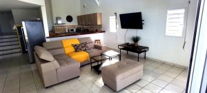 a living room with a couch and a chair at DV REAL PHILOXENIA Villa in Oyster Pond