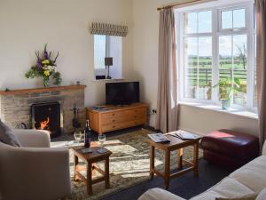 a living room with a fireplace and a tv at Abbotts Close Cottage in Bagby