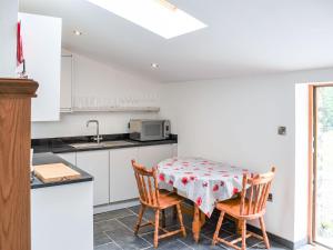 a kitchen with a table and chairs and a sink at Slade Cottage - Uk35027 in Highbray