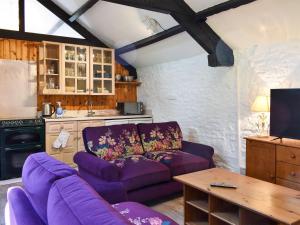 a living room with a purple couch and a table at Heron Cottage-uk32944 in Great Salkeld