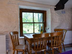 a dining room table with chairs and a window at Heron Cottage-uk32944 in Great Salkeld