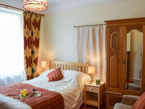 um quarto com uma cama, uma cómoda e um espelho em St Cuthberts Retreat em Wooler