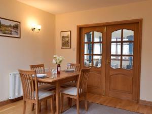 a dining room with a wooden table and chairs at Quiet in Whauphill