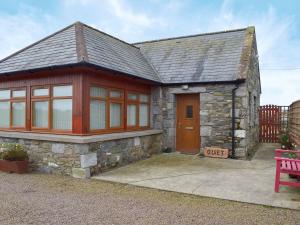 a stone house with a red bench in front of it at Quiet in Whauphill