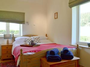 a bedroom with a bed with blue towels on it at Longknowe Barn in Branxton