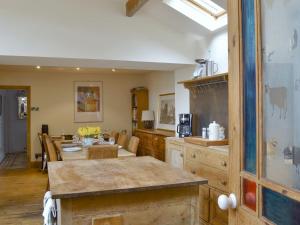 a kitchen and dining room with a table and a counter at Halstead Green Farm in Mytholm