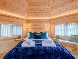 a bedroom with a bed in a wooden cabin at Dragon Fly Retreat-uk36831 in Pentney