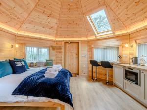 a bedroom with a bed in a wooden cabin at Dragon Fly Retreat-uk36831 in Pentney