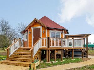 a tiny house with a large porch and stairs at Dragon Fly Retreat-uk36831 in Pentney