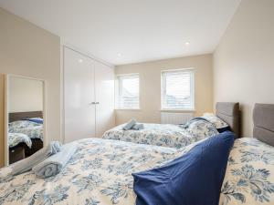 a bedroom with two beds and a mirror at Tyr Ywen Cottage in Abergavenny