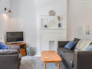 a living room with a couch and a tv at Church View in Lynmouth