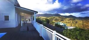 a balcony of a house with a view of the mountains at DV REAL PHILOXENIA Villa in Oyster Pond