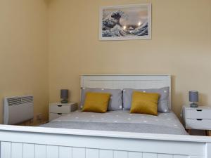 a bedroom with a bed with two yellow pillows at Capstone Reach in Ilfracombe