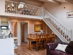 Rimington的住宿－Roosters Rest - Uk31826，用餐室以及带桌子和楼梯的厨房
