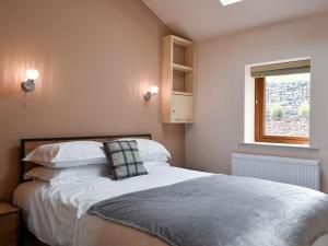 a bedroom with a bed with white sheets and a window at Roosters Rest - Uk31826 in Rimington