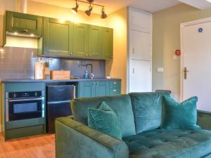 a living room with a green couch in a kitchen at Starfall in Aysgarth