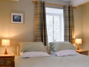 a bedroom with a bed with two pillows and a window at Starfall in Aysgarth