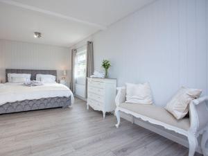 1 dormitorio blanco con 1 cama y 1 silla en Lookout Lodge-uk36700, en Newton Abbot