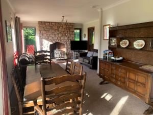 a living room with a table and chairs and a fireplace at Harelaw Brae in Grantshouse