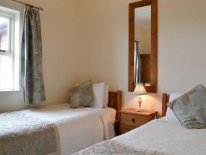a bedroom with two beds and a mirror at Powis Castle View in Forden