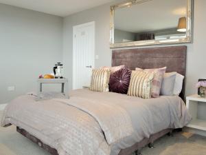 sypialnia z dużym łóżkiem z lustrem na ścianie w obiekcie Hillside Retreat w mieście Prestatyn
