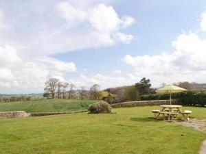 a picnic table and an umbrella in a field at North Farm Bungalow in Horsley