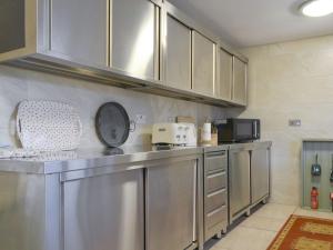 a kitchen with stainless steel cabinets and a counter top at Holly Cottage in Cockermouth