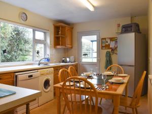 a kitchen with a table and a dining room at Little Blagdon Bungalow in North Tamerton