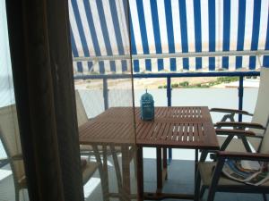 una mesa de madera con un jarrón en la parte superior de una ventana en Duplex en Garrucha a 6 minutos de la playa, en Garrucha