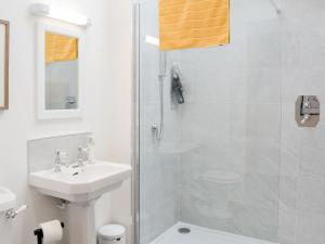 a white bathroom with a shower and a sink at The Garden Rooms in Montrose