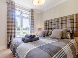 a bedroom with a large bed with a large window at Nanny Goat Lodge in Crossway Green