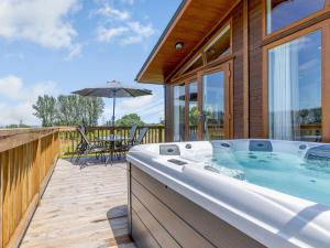 a hot tub on the deck of a house at Nanny Goat Lodge in Crossway Green
